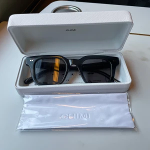 Svarta solglasögon från Chimi - Snygga svarta solglasögon från Chimi med en klassisk fyrkantig form. De har en stilren design med mörka linser och små detaljer på bågarna. Perfekta för att ge en cool touch till din outfit. Sprillans nya och inte använda. Kan gå ner i pris vid snabb affär. Modell 04 darkgrey