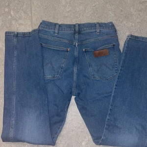 Wrangler Frontier blå jeans W29 L32 - Klassiska Wrangler Frontier jeans i blå denim med raka ben och femficksdesign. Snygga kontrastsömmar, läderpatch bak och normal passform. Perfekta för dig som gillar tidlös stil och vill ha ett par jeans som funkar till allt.(nya kostar 799kr) köppp nuuuu!!!!!!