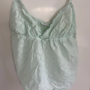 Turkos broderad linnetopp - Supersöt ljusgrön linnetopp med tunna axelband och v-ringning. Dom två sista bilderna är från när jag har haft den på, superbra skick och sällan använd, säljer då jag vill spara upp till en sak!❤️ Pris kan diskuteras