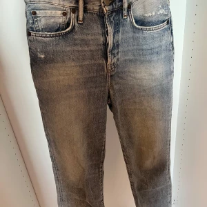 Acne Studios ljusblå raka jeans - Snygga ljusblå jeans från Acne Studios med klassisk femficksmodell och raka ben. Jeansen har en cool tvättad look med slitningar och detaljerade sömmar. 