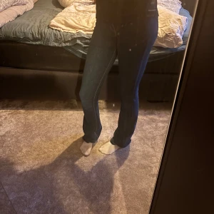 Mörkblå jeans från Scalpers, stl 34 - Snygga mörkblå jeans från Scalpers i klassisk rak modell. Jeansen har kontrastsömmar och normal passform, tillverkade i mjukt bomullstyg med en hint av stretch för extra komfort. Perfekta till sneakers eller boots.