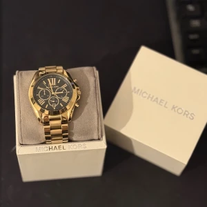 Michael Kors Herrklocka - Säljer en mycket fin Michael Kors herrklocka, guldfärgad med svart urtavla & romerska siffror. Endast använd ett fåtal gånger. Original box, instruktionsbok och extra länkar medföljer.   Nypris: 3000 kr. Mitt pris: 1000kr  Skickas eller hämtas i Uppsala. 