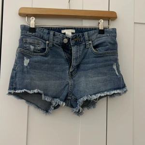 Blå jeansshorts med fransig kant H&M - Snygga blå jeansshorts från H&M i storlek 32. Jag skulle säga att de är midwaist, men går att vika ner så de blir lowwaist. Pris kan diskuteras❤️