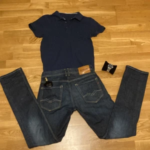 Mörkblå pikétröja från Kappahl - Snygg mörkblå pikétröja från Kappahl i klassisk modell med krage och knappar framtill. T-shirten är kortärmad och tillverkad i mjuk bomull, perfekt för en clean och stilren look. Ändast pikén medföljer i köp.