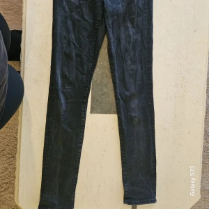 Mörkblå skinny jeans från H&M - Säljer ett par mörkblå skinny jeans från H&M med regular waist. Jeansen är i stretchigt denimtyg och har en smal passform hela vägen ner. Perfekta för dig som gillar en tajt look och klassisk stil.