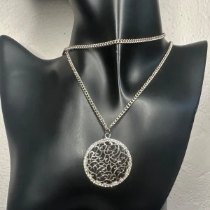 Romantiskt vintagehalsband m glittrande filigranhänge - Snö of Sweden Y2K 90-tal 00-tal - Stilfullt Y2K-halsband från SNÖ of Sweden med långt kedjehalsband (ca 80 cm) och stort hänge (ca 4 x 3,5 cm) i silverfärgad metall med filigrandetaljer och klara gnistrande stenar. Märkt med varumärkesbricka vid låset. Mycket gott skick. Ingen prutning – men jag erbjuder bundlerabatt. Jag rensar smyckesskrin och garderob – spana gärna in mina andra annonser!  ⸻