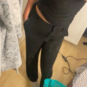 Svarta slim straight kostymbyxor Vero Moda - Svarta kostymbyxor från Vero Moda i modellen VMZAMIRA MW Slim Straight Pant. Snygg midwaist passform med raka ben och diskret dragkedja. Perfekta till en chill eller stilren look. Materialet är mjukt och stretchigt för extra komfort.