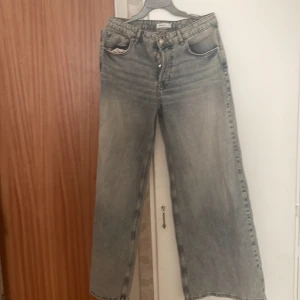 Ljusgråa wide jeans med hög midja - Säljer ett par ljusgråa jeans med breda ben och hög midja. Jeansen har klassisk femficksdesign och en snygg tvättad look. Perfekta för dig som gillar en avslappnad och trendig stil.