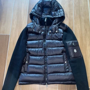 Ny Moncler Cardigan med luva - Moncler Cardigan i nyskick - aldrig använd. Storlek L men kan passa M. Väldigt clean och sällsynt modell. Den är gjord av skönt material och sitter sjukt bra på kroppen. Passar alla outfits och matchar med alla färger. Kan frakta samt mötas upp!