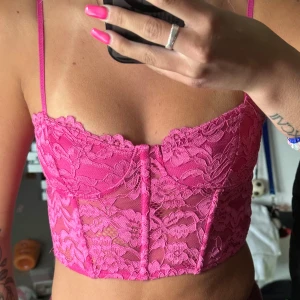 Rosa spetskorsett med tunna axelband - Säljer en superfin rosa korsettopp i spets med blommigt mönster. Använd ca 3 gånger 