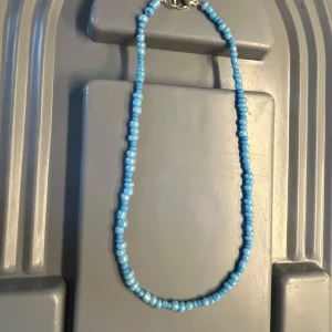 Blått pärlhalsband med silverlås - Ett snyggt halsband med oregelbundna blå pärlor och ett klassiskt silverfärgat lås. Perfekt för dig som vill ha en färgklick till din outfit. Det är handgjort!💙