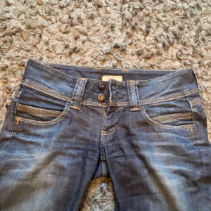 Mörkblå jeans från Pepe Jeans Venus - Snygga mörkblå jeans från Pepe Jeans, modell Venus. Jeansen har låg midja, raka ben och klassiska kontrastsömmar. Tillverkade i stretchig denim av bomull och elastan för en bekväm passform. Flera fickor fram och bak med coola detaljer.