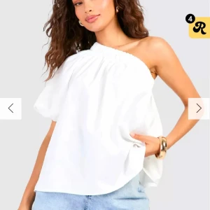 Vit oneshoulder topp med lös passform - Säljer jätte snygg oanvänd vit oneshoulder topp!