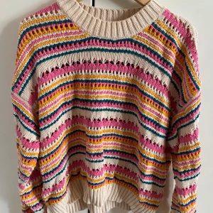 Randig stickad tröja från Zara - Jättesöt färgglad stickad tröja från Zara med breda ränder i rosa, gul, grön och beige. Tröjan har en ribbad rund halsringning och lång ärm. Knappt använd. Passar allt från S-L.