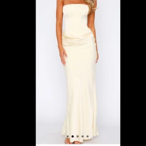 Champagnefärgad lång klänning med snörning - Supersnygg axelbandslös långklänning i champagnefärgad satin-look. Figurnära passform med markerad midja och snygg snörning i ryggen. Klänningen har en lätt drapering vid höften och en elegant, slät kjol som faller mjukt ner mot golvet. Perfekt för bal, examen, whiteparty eller student! Klänningen är omsydd hos professionell skräddare🥰🥰Köpt på White Fox Boutique fraktad från Australien och slutsåld på hemsidan!! Kontakta för fler bilder