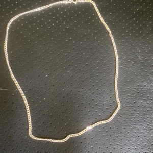 Klassisk  silverkedja halsband - Enkel och stilren tunn halskedja i silverfärg med klassisk karbinlås. Kedjan har tätt länkade små länkar som ger ett diskret och snyggt intryck. Perfekt att bära som den är eller kombinera med ett hänge för en personlig touch.  ÄKTA SILVER