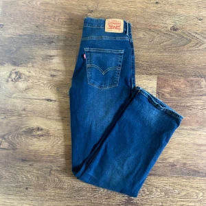 Levi's 551Z blå raka jeans - Säljer ett par klassiska Levi's 551Z jeans i mörkblå denim. Modellen är straight fit med raka ben och snygga kontrastsömmar. Jeansen har fem fickor, bälteshällor och Levi's ikoniska läderpatch bak. Jeansen har aldrig använts. Priset kan diskuteras.
