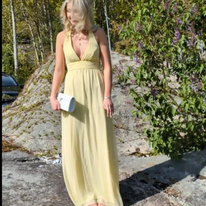 Ljusgul balklänning  - Världens vackraste ljusgula balklänning. Endast använd 1 gång. Öppen i ryggen med knyte i nacken. Från Nelly 💝💖