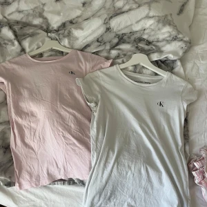 Calvin Klein t-shirts rosa & vit - Säljes 150kr för en, 250 för båda🥰🥰Två stilrena t-shirts från Calvin Klein Jeans, en i ljusrosa och en i vit. Båda har kort ärm, rund halsringning och diskret CK-logga broderad på bröstet. Sköna i mjuk bomull och passar perfekt till jeans eller shorts. 