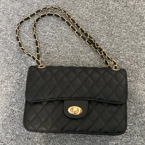 Svart quiltad axelväska från Montini - Snygg svart quiltad axelväska från Montini. Helt ny 10/10 skick. Går för 250 på ur&penn.