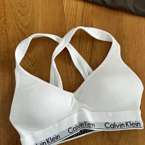 Calvin Klein bh - Vit bralette från Calvin Klein med vadderad bygellös kupa som sitter skönt mot kroppen. Perfekt för en sportig och avslappnad look. Oanvänd! Priset kan diskuteras 