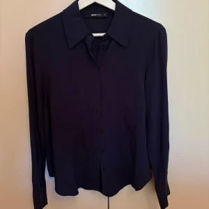 Mörkblå skjorta från Gina Tricot XS - Stilren mörkblå skjorta från Gina Tricot i storlek XS. Perfekt för en clean och enkel look. Använd endast en gång.