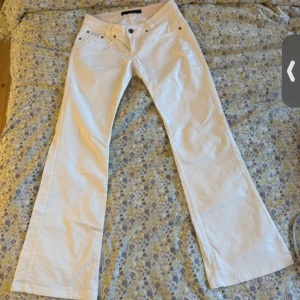 Vita bootcut jeans från Calvin Klein - Snygga vita bootcut jeans från Calvin Klein Jeans. Modellen har klassisk femficksdesign, låg midja och bootcut. Waist 27 - L34