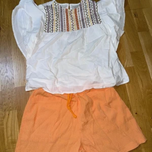 Persikofärgade shorts med snörning - Snygga persikofärgade shorts med avslappnad passform och elastisk midja med snörning. Materialet är lätt och har en krinklad struktur som ger en chill vibe, perfekt för varma dagar. Shortsen har en enkel design utan mönster och passar till allt. Bara använt 2 gånger 