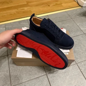 Mörkblå Loubs  - Ny skick.                                                                Storlek 43. Sitter bra i storlek                                                          Snygga mörkblå sneakers från Louboutin i mocka med klassisk röd sula och diskret logga undertill. 