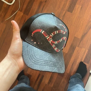 GG keps - Svart keps med en orm på.