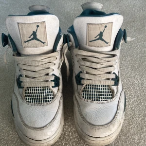 Nike Air Jordan 4 Retro vit/grön - Nike Air Jordan 4 Retro sneakers i vitt skinn med gröna detaljer och meshpaneler. Klassisk Jumpman-logga på plös och häl, snörning framtill och vadderad insida. Snygg high-top siluett som sticker ut.