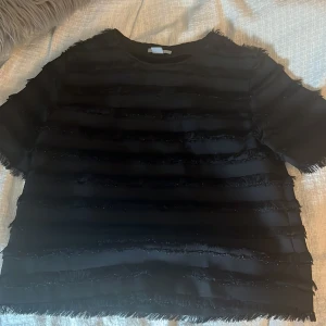 Svart randig topp från H&M - Säljer nu min fina hm topp med fransar. Den är aldrig använd och är i storlek 36🥰 så fin