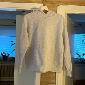 Ljusgrå hoodie från Primark Cares - En stilren ljusgrå hoodie från Primark Cares i storlek M. Tröjan har klassisk huva, magficka och långa ärmar. Perfekt för chill dagar eller när du vill ha en enkel och clean look. Materialet är mjukt och skönt, troligtvis bomullsmix.
