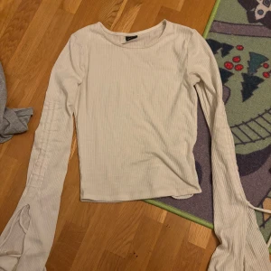 Vit ribbad långärmad tröja Gina Tricot - Supersnygg vit ribbad långärmad tröja från Gina Tricot i storlek XXS. Tröjan har en tight passform och är tillverkad i mjuk bomullsmix. Perfekt basplagg med rund hals och diskreta ribbade detaljer som ger en stilren look.
