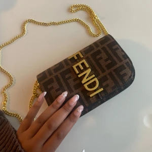 Fendi brun axelväska med kedja - Nu säljer jag min älskade Fendi-väska – en tidlös klassiker som förtjänar att glänsa vidare hos någon ny 💖 Perfekt för dig som vill addera lite lyx till vardagen eller en elegant touch till festlooken!