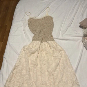 Beige spetsklänning från Zara - Supersöt långklänning från Zara med stickad beige överdel och smala axelband. Kjolen är i ljus spets med broderade blommor och ger en romantisk vibe. Perfekt för sommarens alla tillfällen när du vill känna dig extra fin.