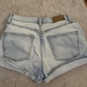 Ljusblå jeansshorts  - Snygga ljusblå jeansshorts från 157 med hög midja och uppvikta benslut. 