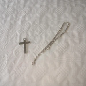 Silver halsband med kors inga repor  - Stilrent halsband med ett stort kors i silverfärg. Korset har en liten ingraverad detalj i form av ett mindre kors upptill. Kedjan är tunn och matchar hängsmycket perfekt för en clean look. Perfekt accessoar för dig som gillar minimalistisk stil.