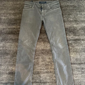 Grå byxor från Handpicked W32 - Snygga grå byxor från Handpicked, tillverkade i Italien. De har en klassisk design med fem fickor och en knappgylf. Perfekta för en stilren look. Nypris cirka 3000kr!