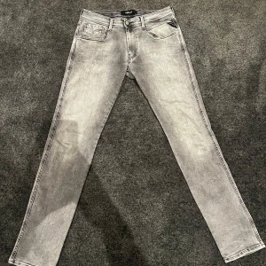 Grå jeansbyxor replay  - Snygga grå jeansbyxor med en klassisk femficksdesign och knappgylf. Perfekta för en stilren look. Replay märke.