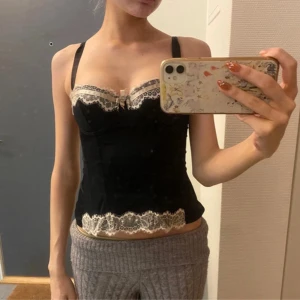 Svart korsett med spetsdetaljer - Den går att stänga där bak men orkade inte…..