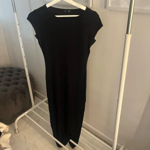 Svart långklänning - Snygg och stilren svart långklänning med korta armar 🤩Modell:CAP SLEEVE DRESS 92% viskos. Använd typ en gång så den är i väldigt fint skick. Skriv meddelande vid frågor/fler bilder 🩷
