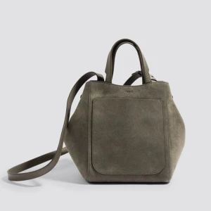 Grön mocka handväska från Filippa K - Snygg grön handväska i mocka från Filippa K. Väskan har en stilren design med en praktisk ytterficka och bekväma handtag. Läder och mocka. 2 innefickor. Det långa axelremmen saknas. Storlek 25x25