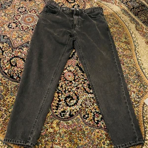 Mörkgråa jeans från Pull&Bear - Snygga mörkgråa jeans från Pull&Bear med klassisk femficksdesign och dragkedja. Perfekta för en avslappnad stil. Tillverkade i ett slitstarkt material som ger en skön passform.