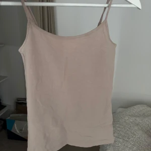 Beige linnetopp - Säljer en enkel och stilren beige linnetopp med tunna axelband. Perfekt för varma sommardagar eller som ett basplagg i garderoben. Jag säljer då den aldoeg har blivit använd. ☺️☺️