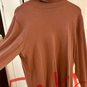 Grå kappa med knappar - Elegant grå kappa med knappar framtill och två fickor. Perfekt för kyligare dagar med sin stilrena design och långa ärmar.