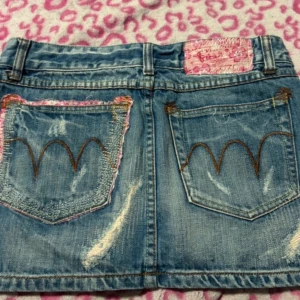 Jeanskjol med slitningar och broderi - Jätte fin jeanskjol med rosa detaljer. Köpte från Vinted fast har inte använt den, jätte fin o perfekt för sommaren 💕