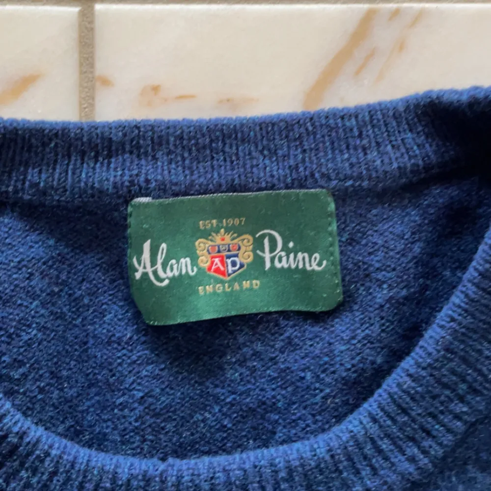 Säljer en klassisk blå tröja från Alan Paine. Plagget har rund halsringning passé perfekt med en skjorta under. Plagget har en mindre defekt i mitten av framsidan (se bild 3). Kom gärna privat för frågor m.m.🙌. Neuletakit & Villapaidat.