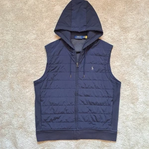 Ralph Lauren Väst Med Luva - Stl L - Hej säljer en snygg Ralph Lauren väst med luva. Den är marinblå och riktigt fet! Perfekt nu till våren, sommaren och hösten. 🏝 Storlek: L. Rekomderas att vara runt 180cm. Skick: 9/10 utan defekter. Mycket bra! Hör av dig om du har några frågor. Mvh Galgen 🤗