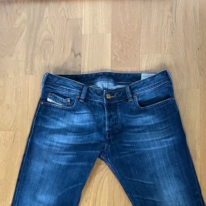Diesel jeans  - Säljer ett par klassiska mörkblåa jeans från diesel. De har en bootcut passform. W31 L32 men de är lite korta i längden. Perfekta för en avslappnad stil.